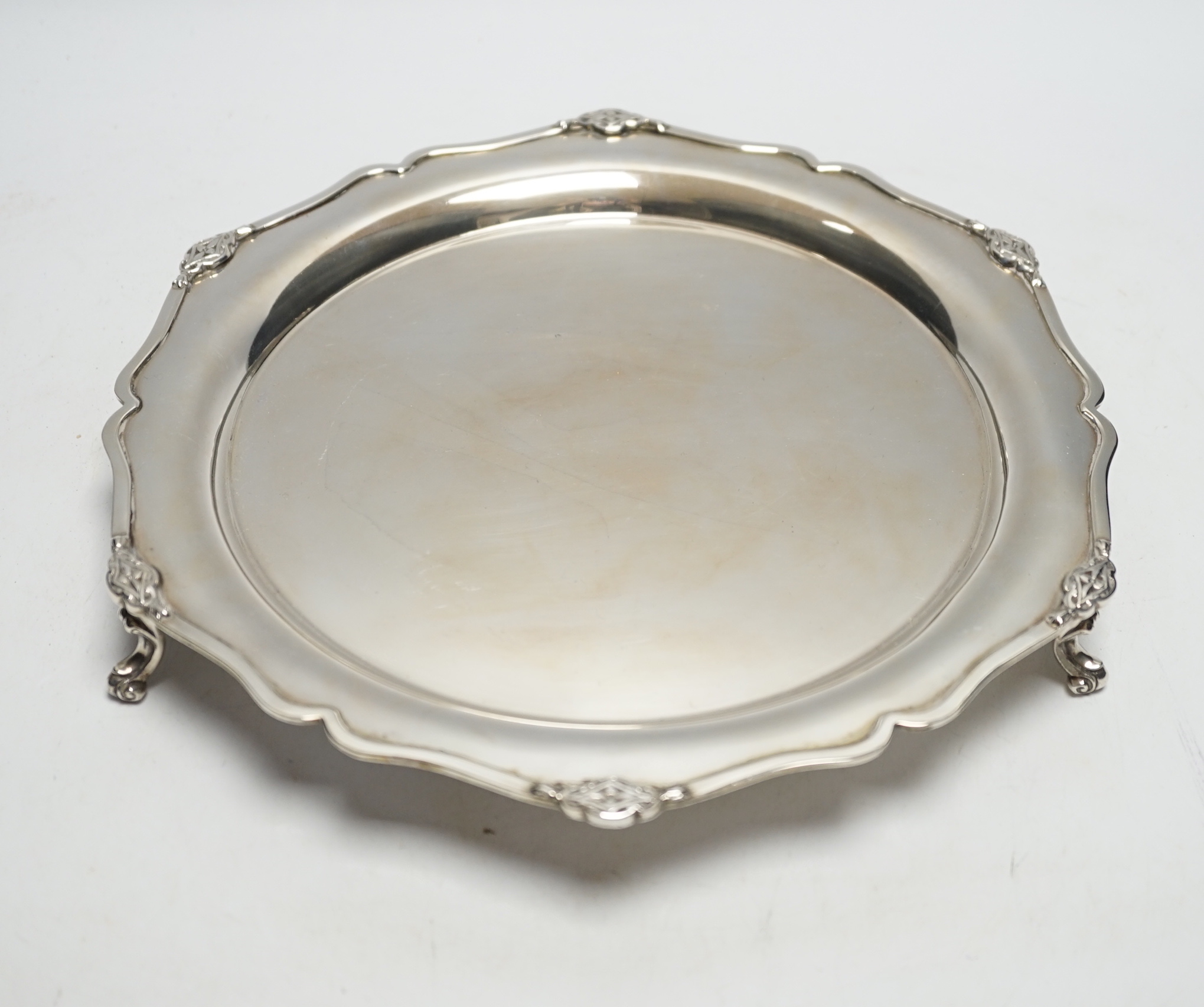 A George V silver shaped circular salver, on three scroll feet, Martin, Hall & Co, Sheffield, 1929, 26.9cm, 17.2oz.